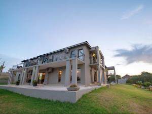 a large white house with a lawn in front of it at Altissimo Guesthouse in Bloemfontein