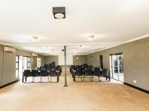a conference room with a table and chairs in it at Altissimo Guesthouse in Bloemfontein