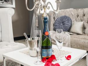 a bottle of wine sitting on a table with glasses at Altissimo Guesthouse in Bloemfontein