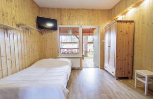 a bedroom with a bed and a tv on a wall at Relaks Boszkowo in Boszkowo-Letnisko