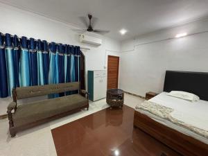 a bedroom with a bed and a window with blue curtains at Trivrindam Hotel in Gorakhpur