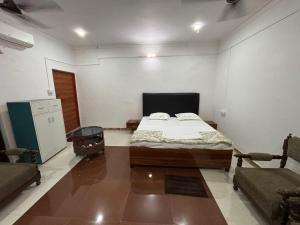a bedroom with a bed and a couch in it at Trivrindam Hotel in Gorakhpur +4 photos