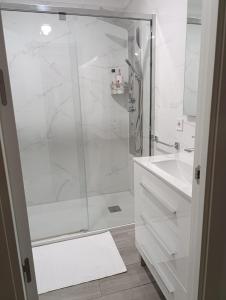 a white bathroom with a shower and a sink at SUNSHINE GROUP in Málaga +10 photos