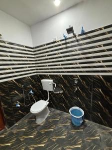 a bathroom with a toilet and a large wooden wall at Trivrindam Hotel in Gorakhpur