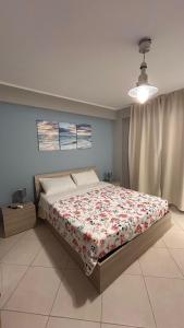 a bedroom with a bed with a floral bedspread at La camera a Lido Burrone in Favignana