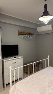 a bedroom with a bed and a flat screen tv at La camera a Lido Burrone in Favignana