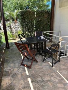 a black table and two chairs on a patio at La camera a Lido Burrone in Favignana