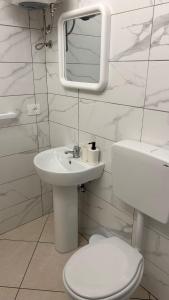 a white bathroom with a toilet and a sink at La camera a Lido Burrone in Favignana