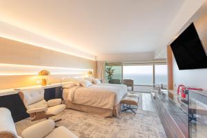 a hotel room with a bed and a flat screen tv at Sitges Suites - Premium in Sitges