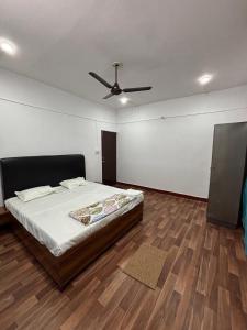 a bedroom with a bed and a ceiling fan at Trivrindam Hotel in Gorakhpur