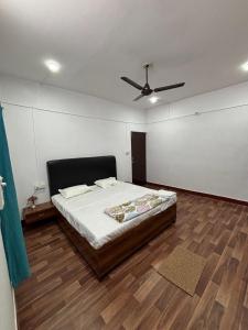 a bedroom with a bed and a ceiling fan at Trivrindam Hotel in Gorakhpur