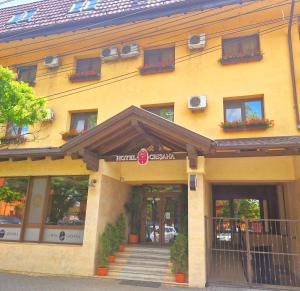 a large yellow building with windows and stairs in front at Hotel Crisana Arad in Arad