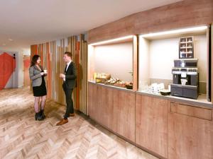 a man and a woman standing in front of a counter at Novotel Wavre Brussels East in Wavre +131 photos