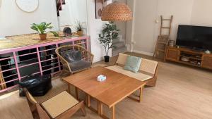 a living room with a table and chairs and a tv at silom lestay纯女民宿 in Yan Nawa