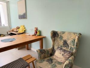 a living room with a table and a chair at silom lestay纯女民宿 in Yan Nawa