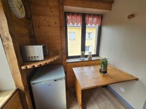 a small kitchen with a table and a microwave at le chale heureux in Gérardmer