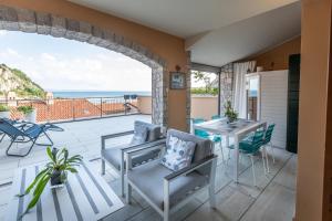a patio with a table and chairs and the ocean at Portopiccolo Avolare Apartments in Borgo, beach included in Sistiana