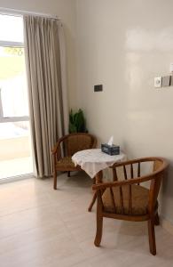 a room with a table and two chairs and a window at Sea Turtles Guest House in Al Ḩadd