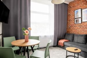 a living room with a couch and a table and chairs at New Adler Bed & Breakfast in Łódź