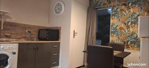 a kitchen with a desk with a computer and a clock on the wall at Studios Saint dye sur Loire in Saint-Dyé-sur-Loire