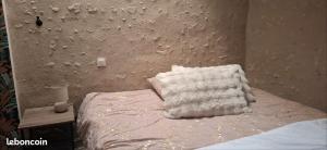 a bed with a white blanket on top of it at Studios Saint dye sur Loire in Saint-Dyé-sur-Loire