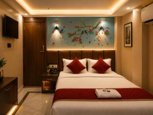 a bedroom with a large bed with red pillows at Orbit guest house by Flying Suites in Kolkata