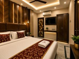 a bedroom with a large bed and a television at Orbit guest house by Flying Suites in Kolkata