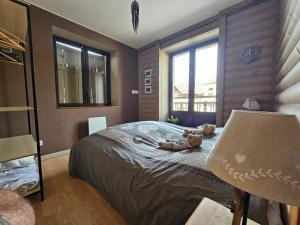 a bedroom with a bed with two teddy bears on it at le chale heureux in Gérardmer