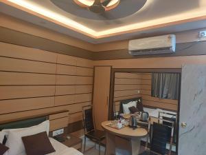 a bedroom with a bed and a desk and a table at Orbit guest house by Flying Suites in Kolkata