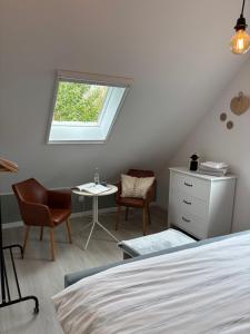 a bedroom with a bed and a table and chairs at De Strandloper B&B Oostduinkerke in Koksijde