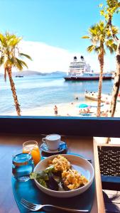a plate of food on a table with a view of the beach at VILLA MARGARIT Boutique Hotel in Sarandë