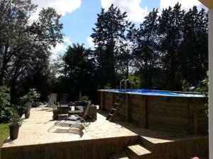 a patio with a swimming pool with a ladder at Chambres - La Chenevelle in Chitenay