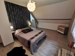a bedroom with a bed with a large headboard at Chambres - La Chenevelle in Chitenay