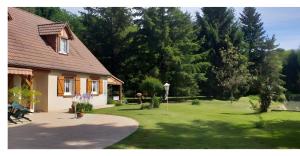 a house with a green yard with trees and a park at Chambres - La Chenevelle in Chitenay