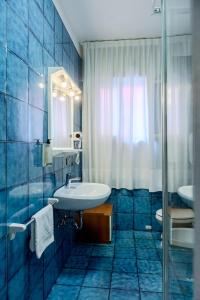 a blue tiled bathroom with a sink and a shower at Villa Lucia in Caorle +48 photos