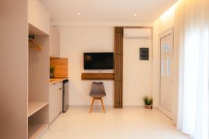 a kitchen with a television and a chair in a room at Erics Apartment in Skala Potamias