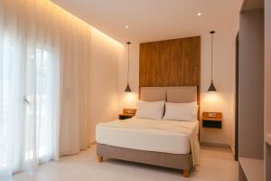 a bedroom with a bed with white sheets and white pillows at Erics Apartment in Skala Potamias +54 photos