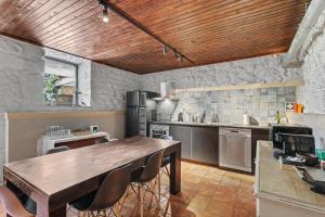 a kitchen with a wooden ceiling and a wooden table at Casa Nova das Oliveiras in Verim