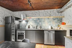 a kitchen with stainless steel appliances and a black refrigerator at Casa Nova das Oliveiras in Verim +17 photos