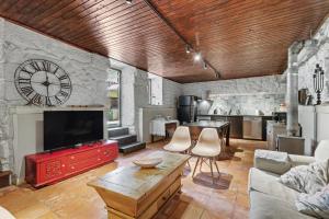 a large living room with a large clock on the wall at Casa Nova das Oliveiras in Verim