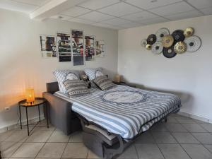 a bedroom with a bed with a blue and white comforter at Châtel-guyon : Appart cosy avec place de parking et piscine près des thermes in Châtel-Guyon
