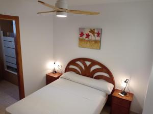 a bedroom with a bed and two night stands with lamps at Parquemar VIII Solo Familias Serviplaya in Playa de Xeraco +51 photos