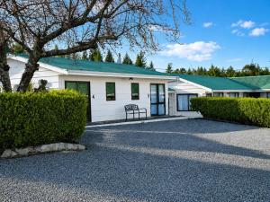 a white building with a green roof at Forest Peak Motel in Hanmer Springs