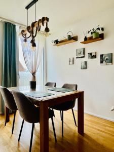 a dining room table with chairs and a chandelier at Modern 1-Bedroom Retreat in Lausanne