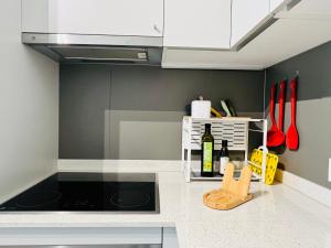a kitchen with white cabinets and a stove top oven at Modern 1-Bedroom Retreat in Lausanne