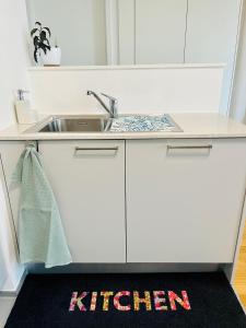 a kitchen with a sink and a kitchen sign on the floor at Modern 1-Bedroom Retreat in Lausanne +17 photos