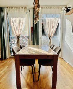 a dining room with a wooden table and chairs at Modern 1-Bedroom Retreat in Lausanne