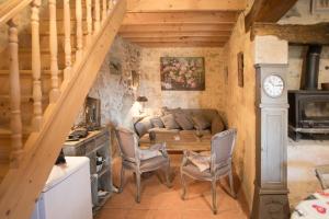 a living room with a couch and a clock on the wall at GITE FOUR A PAIN 4 pers in Bon-Encontre
