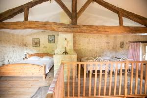 a bedroom with two beds in a room with wooden ceilings at GITE FOUR A PAIN 4 pers in Bon-Encontre +4 photos