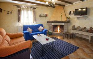 a living room with a blue couch and a fireplace at Matasiete in Laroya